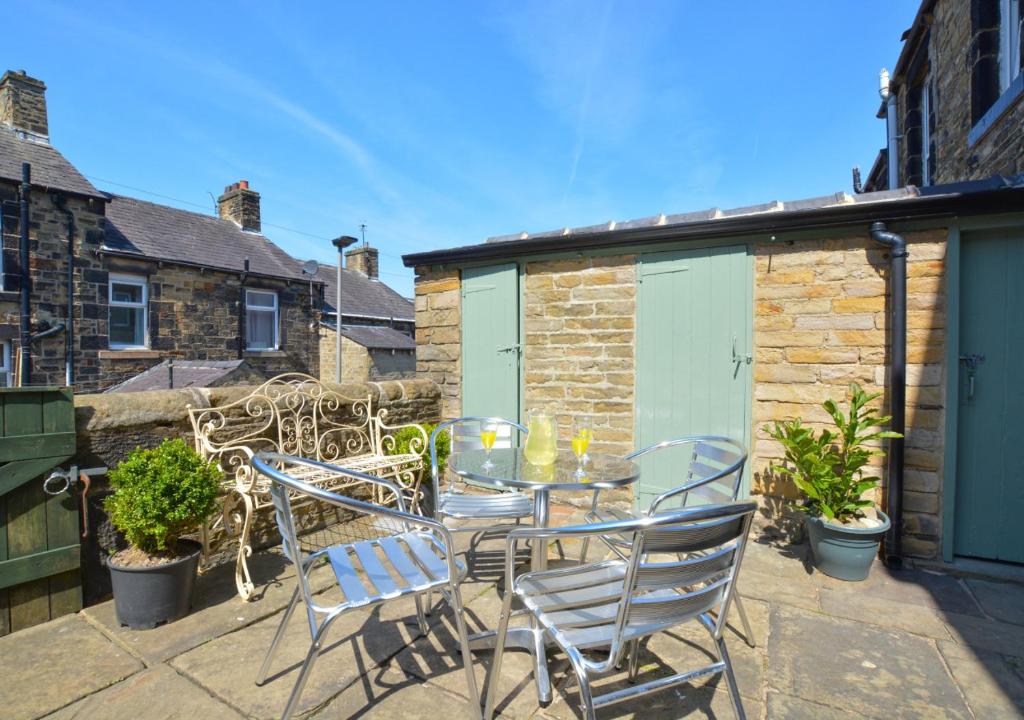 a patio with a table and chairs and a building at Green Gable in Skipton