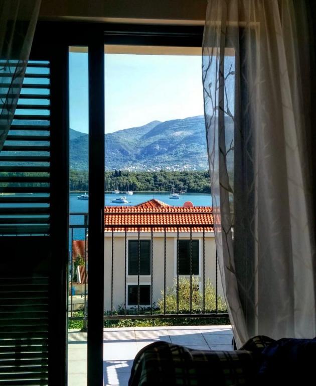 a window with a view of a building at The Wave in Tivat