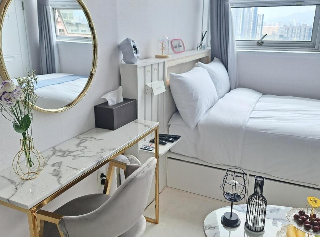 ein kleines Zimmer mit einem Bett und einem Spiegel in der Unterkunft Angel House in Daegu