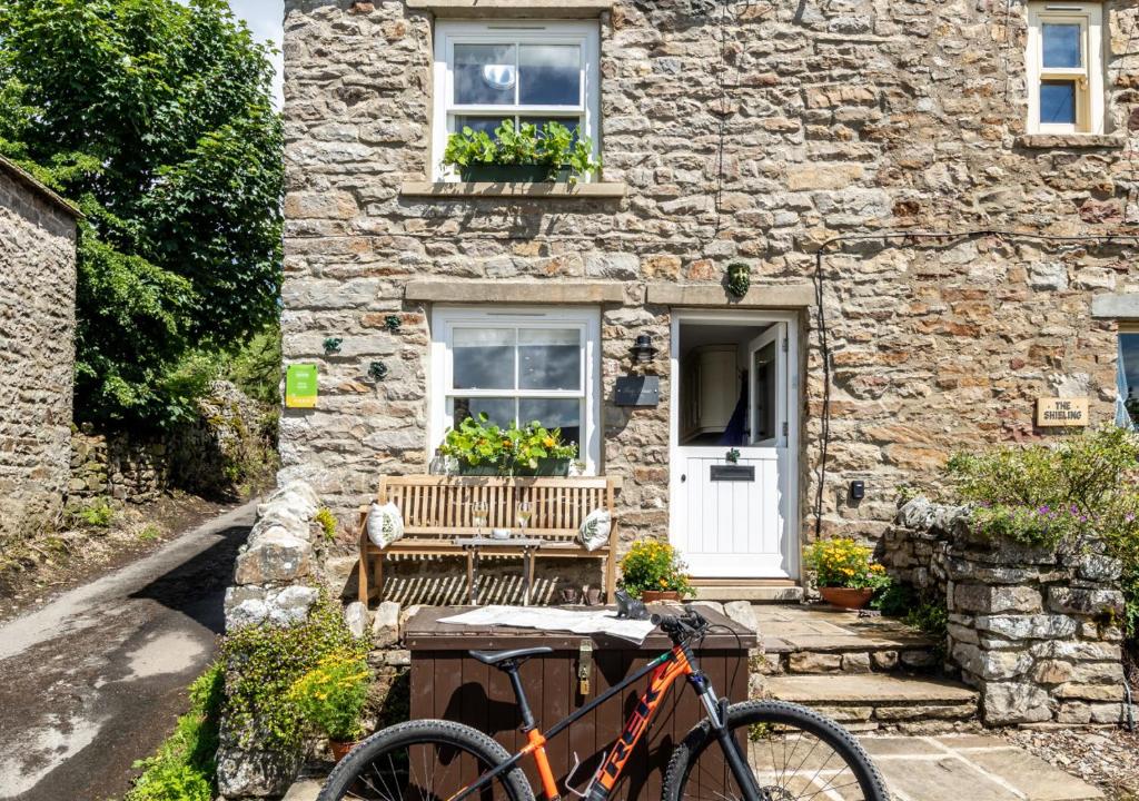 a bike parked in front of a stone house at Frog House in Reeth