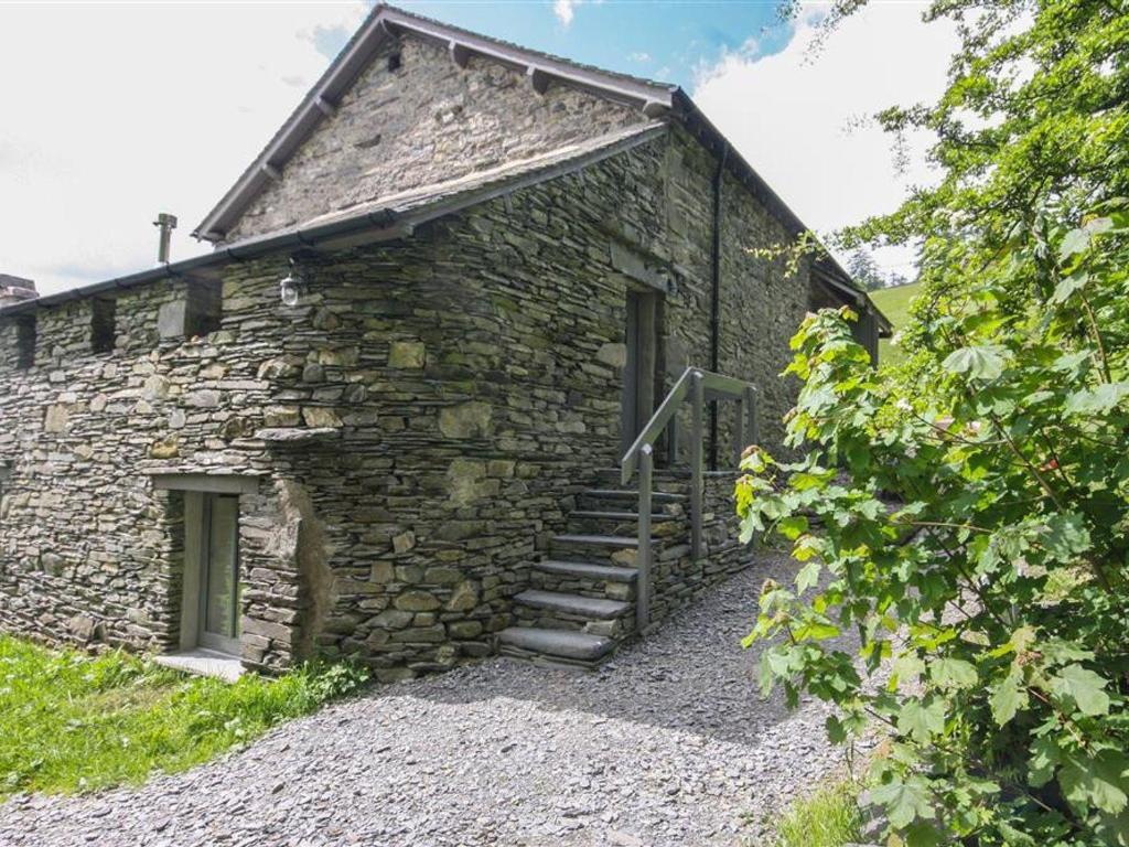 uma antiga casa de pedra com escadas ao lado em Bracken Barn em Ambleside