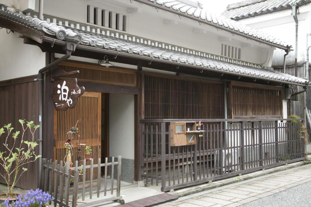un edificio con una puerta y una señal en él en Female-Only Guesthouse Tomari-ya en Tondabayashi