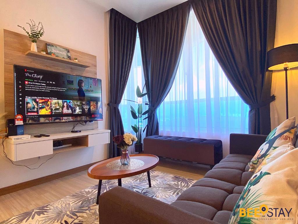 a living room with a couch and a tv at The Wave Suites Melaka by BEESTAY in Melaka