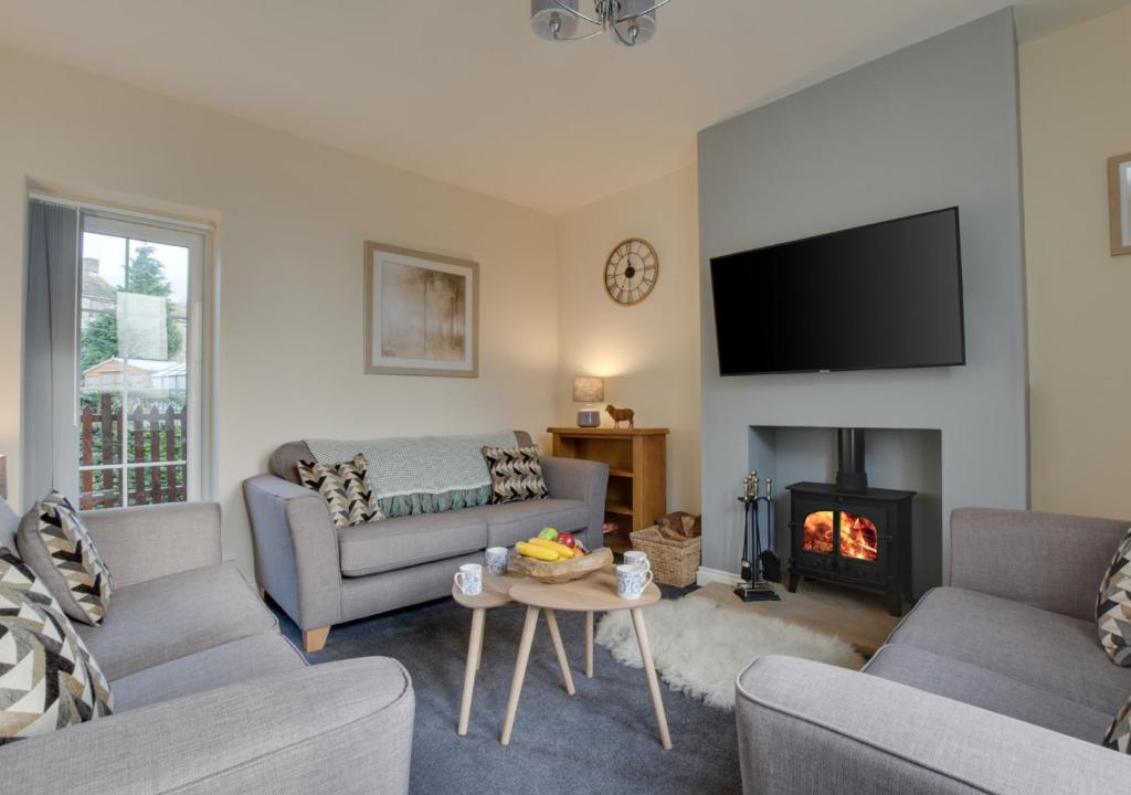 a living room with a couch and a fire place at Fellside in Kettlewell