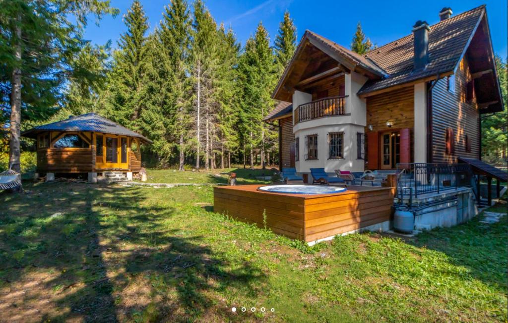 a log home with a hot tub and a gazebo at Luxury Love Chalet in Mrkopalj