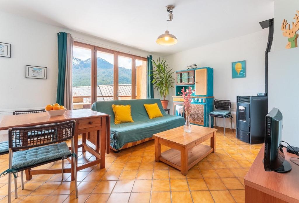 a living room with a couch and a table at Le Petit Lieu Les Orres Appartement Charmant in Les Orres