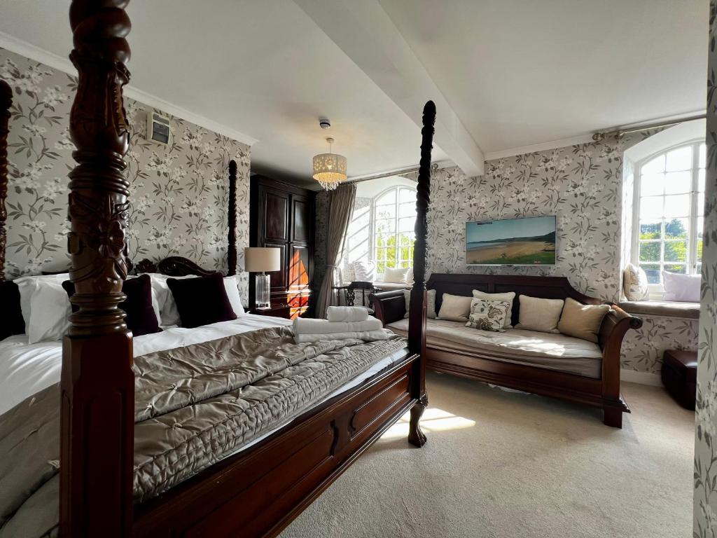 een slaapkamer met een bed en een bank bij Notley Arms Inn Exmoor National Park in Elworthy