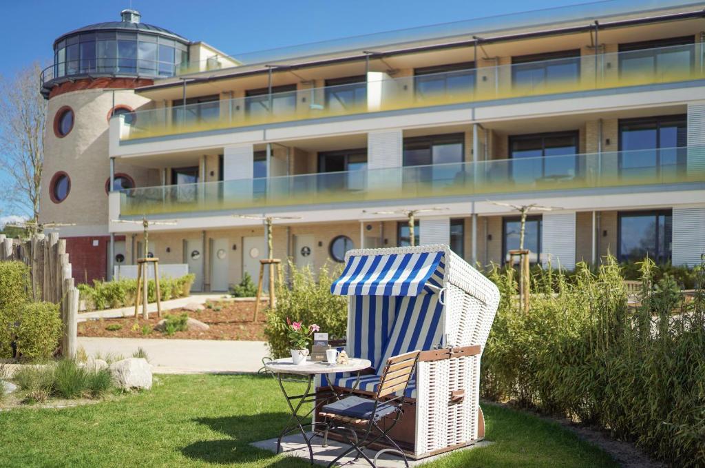 a chair and a table in front of a building at Appartements "Zum Leuchtturm" Hafen Rankwitz Insel Usedom in Rankwitz