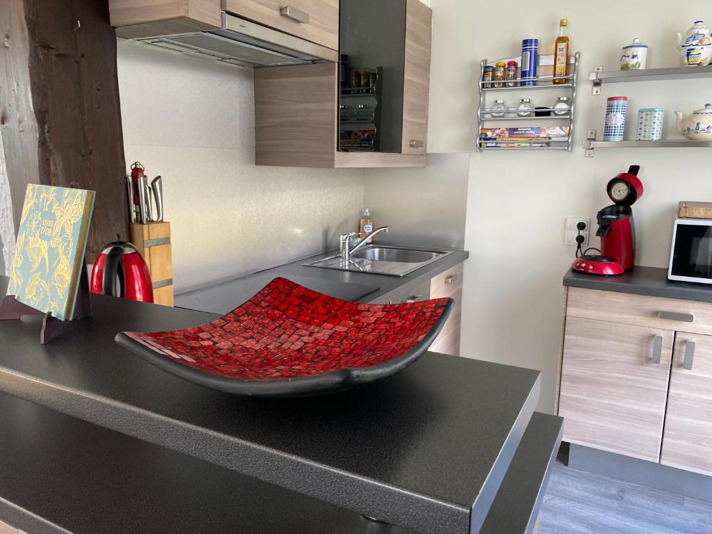a kitchen with a red bowl on a counter at le gîte de Martine en Baie de Somme in Lanchères
