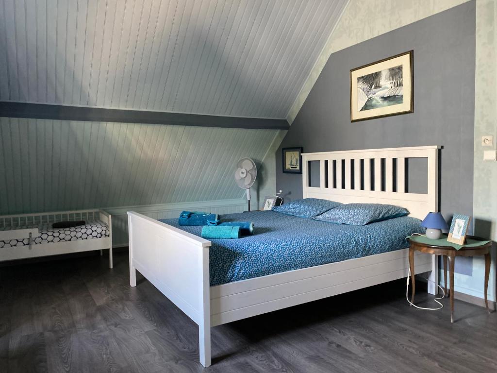 a bedroom with a bed with blue pillows and a ceiling at le gîte de Martine en Baie de Somme in Lanchères