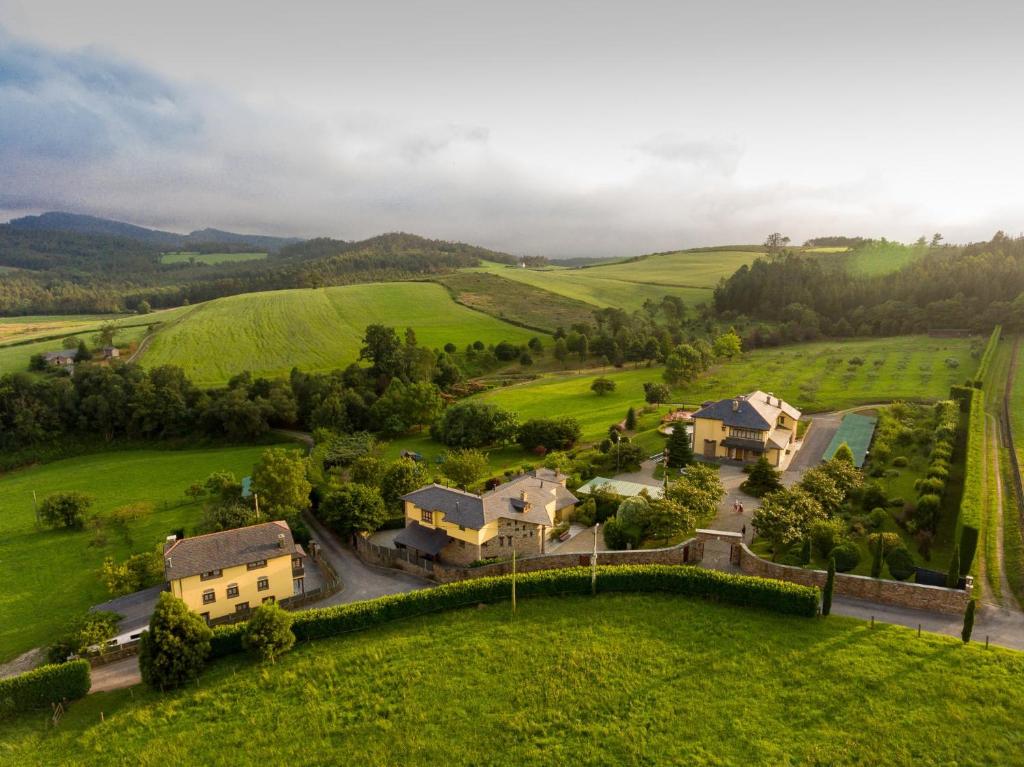 una vista aérea de una casa en un campo verde en Apartamentos Hacienda Llamabua, en Navia