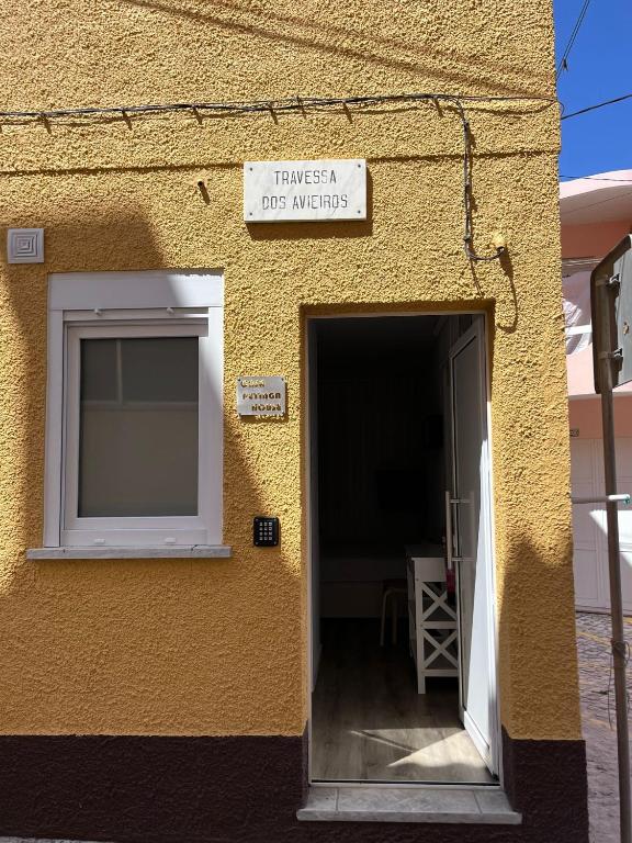 un bâtiment avec une porte et un panneau indiquant les heures d'ouverture d'une crèche pour chiens dans l'établissement CASAS DONA EMILIA, à Vieira de Leiria