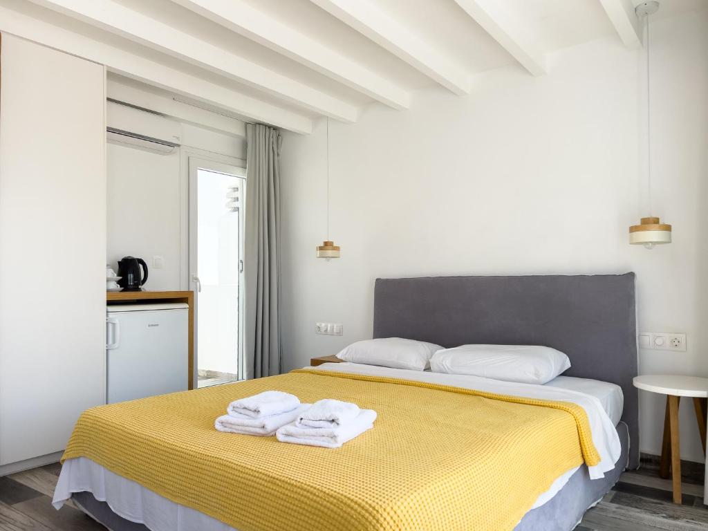 a white bedroom with a bed with towels on it at George Studios in Naxos Chora