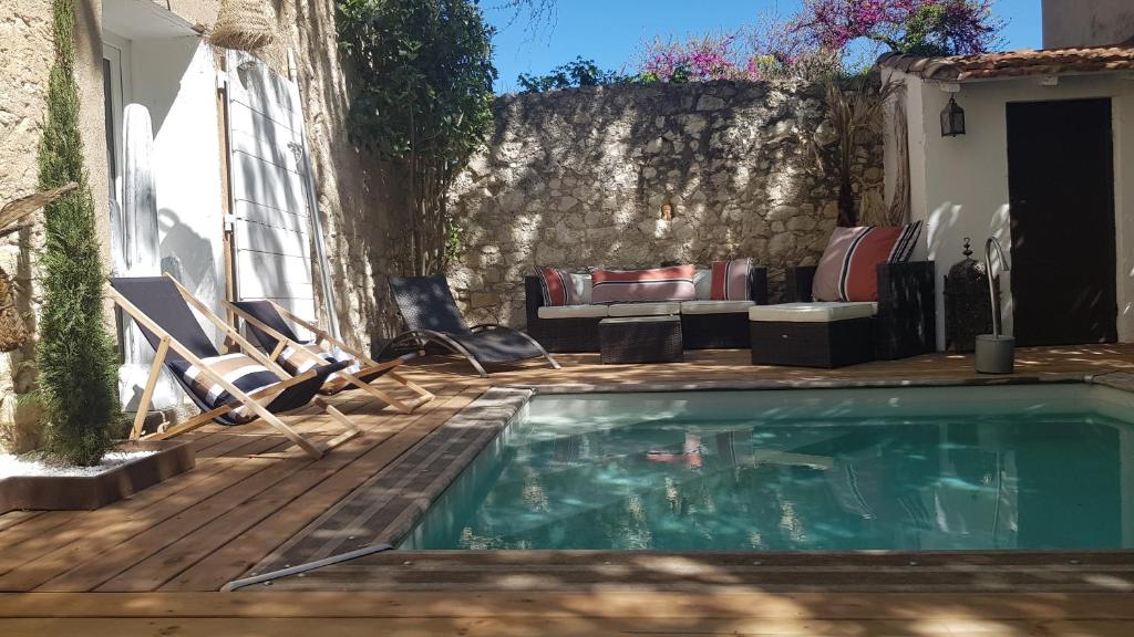 - une piscine sur une terrasse avec des chaises et un canapé dans l'établissement La Demeure du Pressoir, à Cuxac-dʼAude
