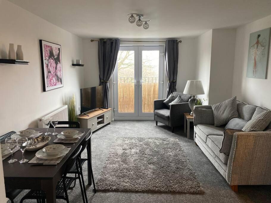 een woonkamer met een bank en een tafel bij Lovely 2nd floor 2 bed flat sleeps 4 in Doncaster