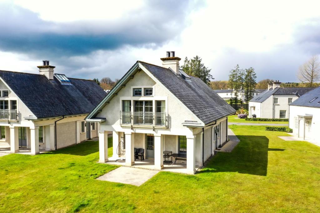 een groot wit huis op een groen gazon bij Escape Ordinary at Lough Erne Golf Village No.52 in Enniskillen