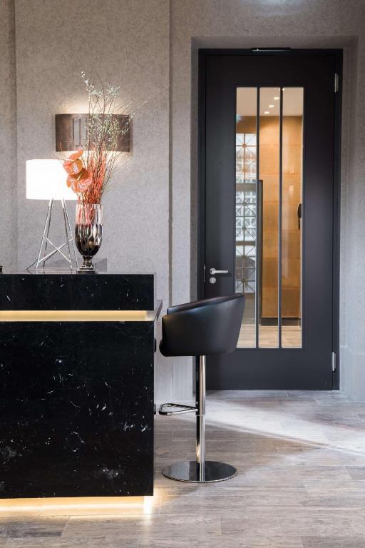 a black desk with a black chair in a room at The Wellem, in The Unbound Collection by Hyatt in Düsseldorf