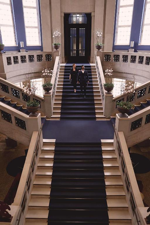 two people walking down a staircase in a building at The Wellem, in The Unbound Collection by Hyatt in Düsseldorf