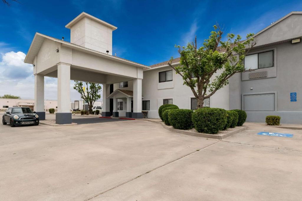 a building with a car parked in a parking lot at Quality Inn & Suites in Artesia