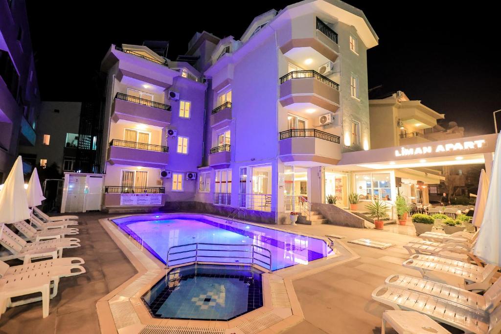 a hotel with a swimming pool in front of a building at Liman Apart Hotel in Marmaris