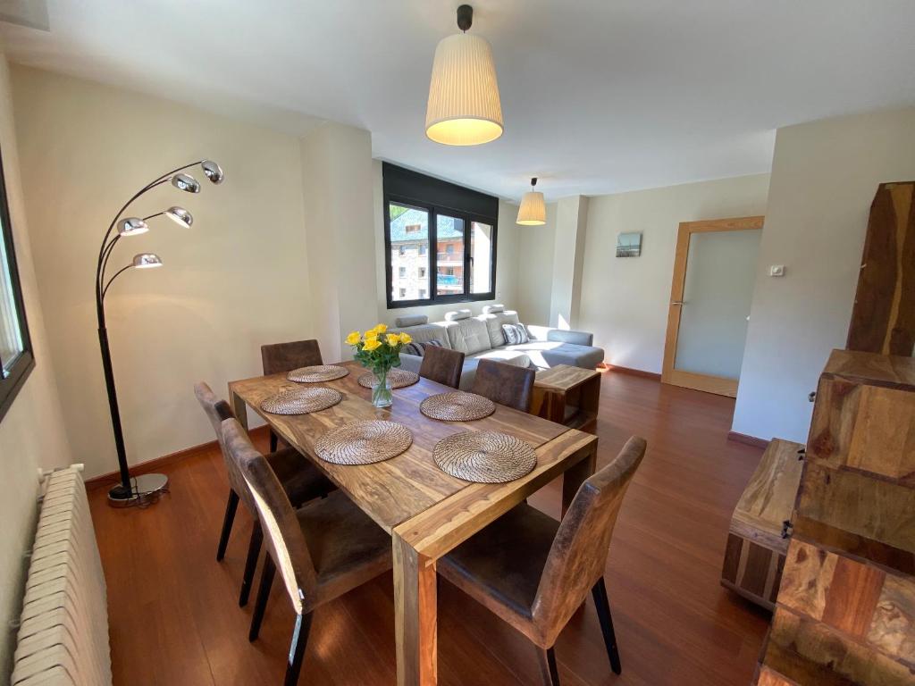 a dining room with a table and chairs and a couch at Canillo L'Areny View in Canillo