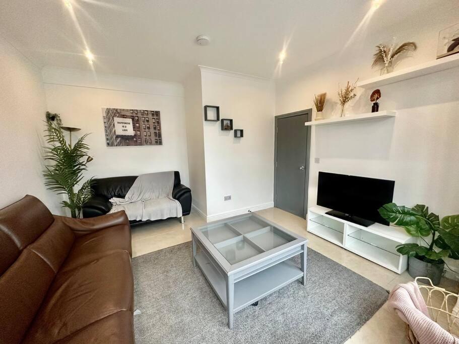Una sala de estar con un sofá y un televisor. en 5 bedroom House SE6, en Hither Green