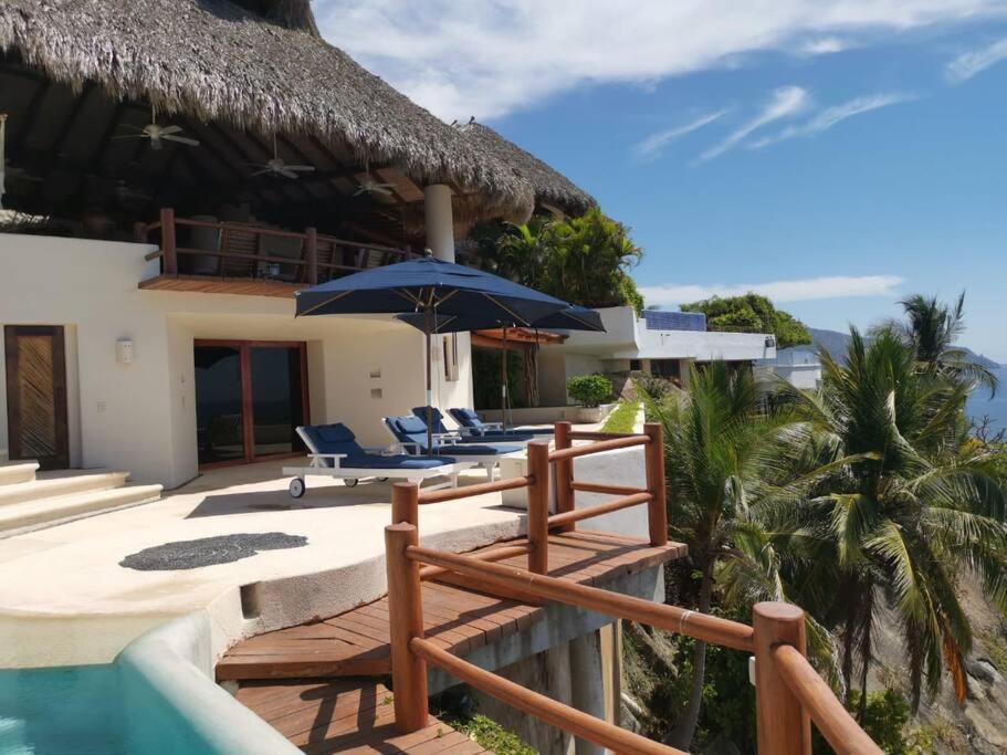 une maison avec une piscine, des chaises et un parasol dans l'établissement Casa Nautilus Ixtapa, espectacular!, à Ixtapa