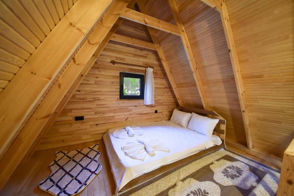 małe łóżko w drewnianym pokoju w kabinie w obiekcie BADEM AĞACI BUGALOWLARI w Kaş