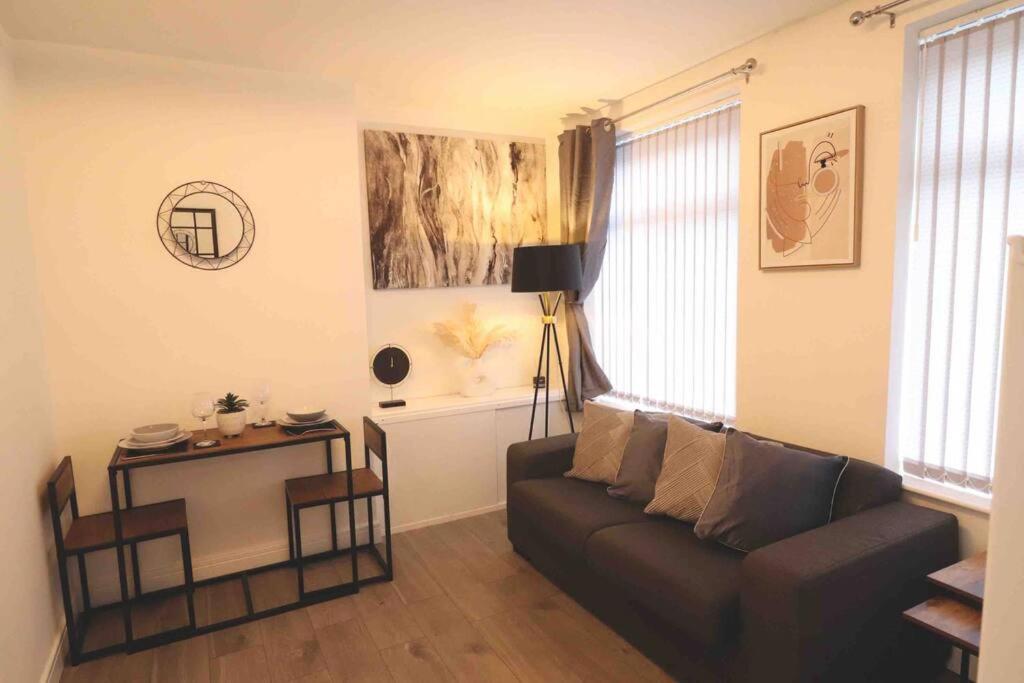 a living room with a couch and a table at Stylish one bed apartment with off road parking in Birmingham