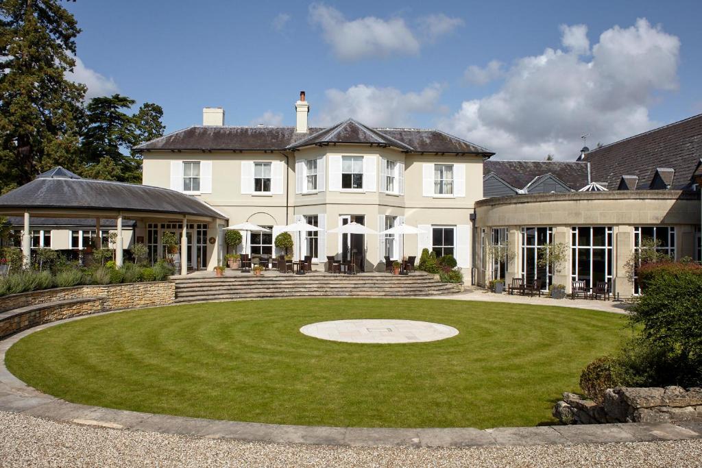 une grande maison blanche avec une grande pelouse dans l'établissement The Vineyard Hotel & Spa, à Newbury