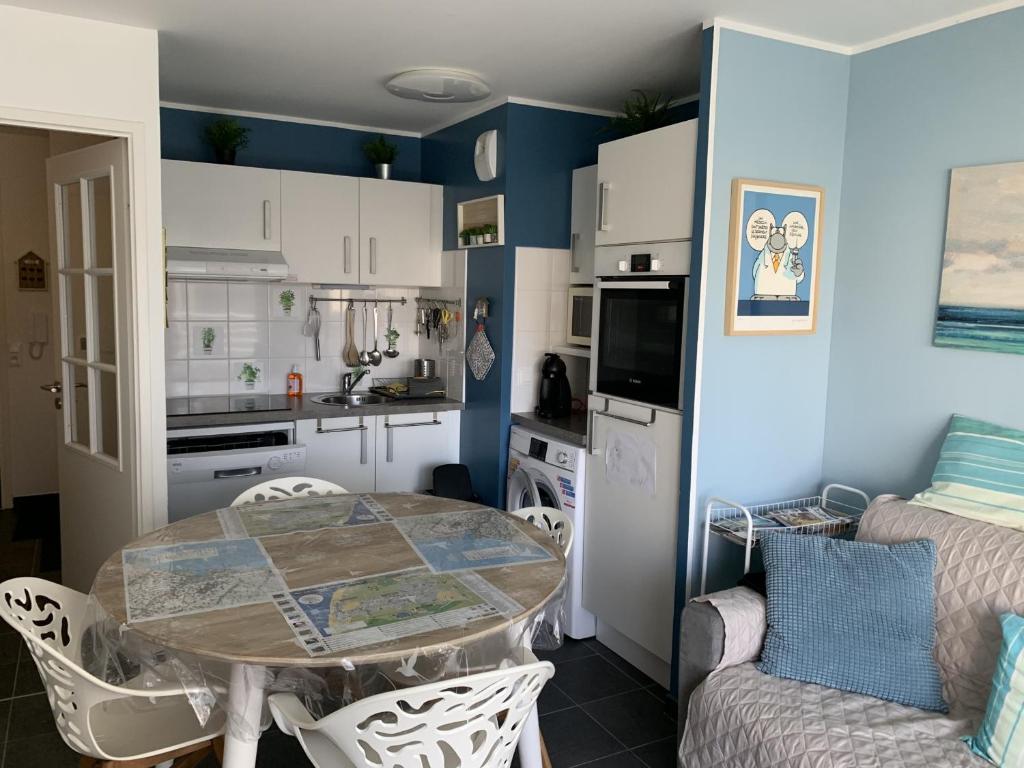 une cuisine et une salle à manger avec une table et des chaises dans l'établissement Appartement familial près de la plage avec parking et balcon verdoyant - FR-1-482-49, à Fort-Mahon-Plage
