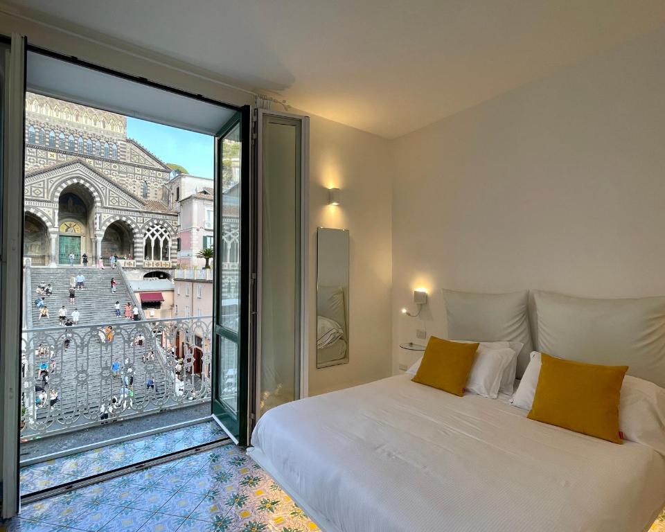 a bedroom with a bed and a large window at Terrazza Duomo in Amalfi