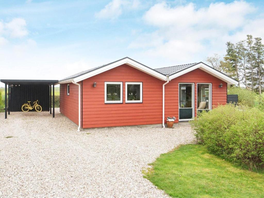 een rood huis met een zwarte garage bij Holiday home Slagelse XIX in Slagelse