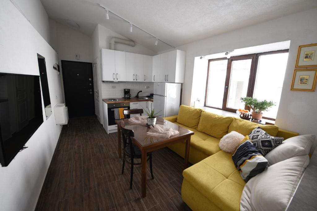 een woonkamer met een gele bank en een tafel bij Old Town Patio House in Ohrid