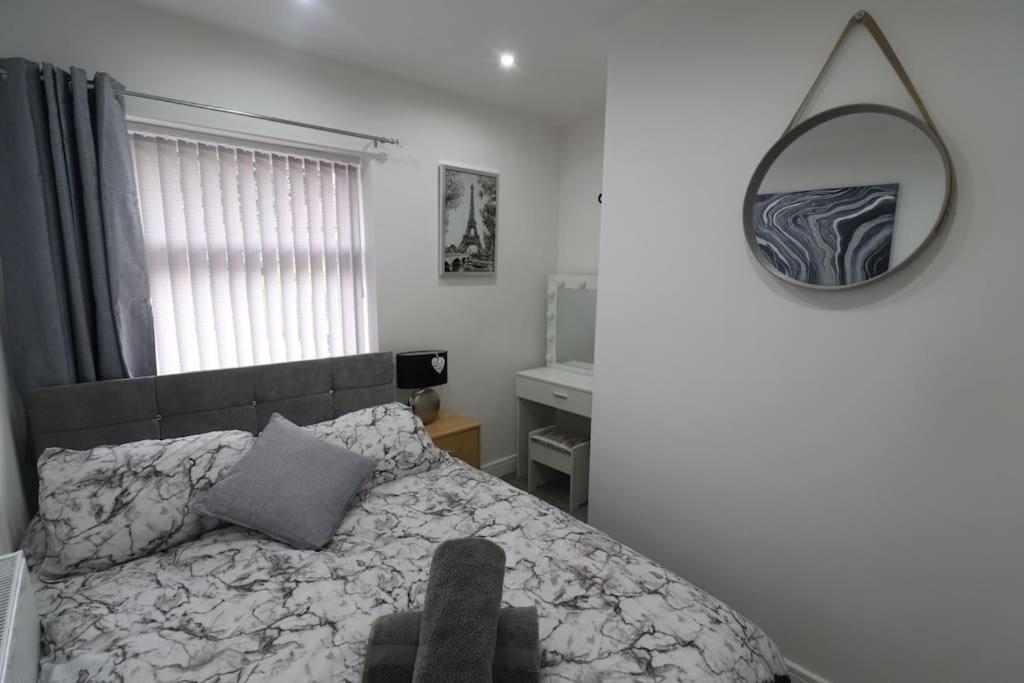 a bedroom with a bed and a mirror on the wall at Cosy two bedroom first floor apartment in Birmingham