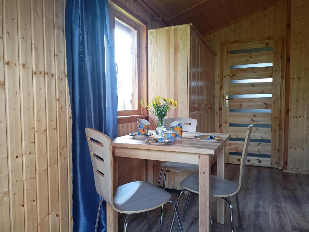 a dining room table with chairs and a window at Domek 1 w Rancho Żnin in Żnin