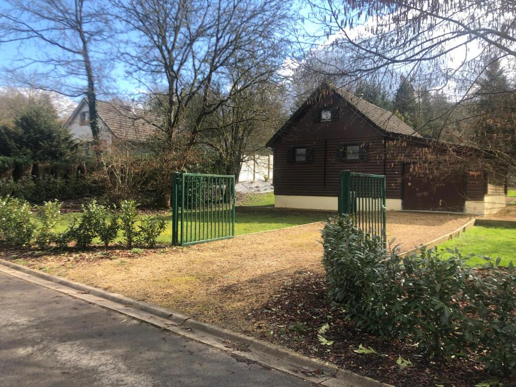 una casa con una puerta verde delante de un patio en Chalet cosy et chaleureux à Wéris près de Durbuy, en Weris