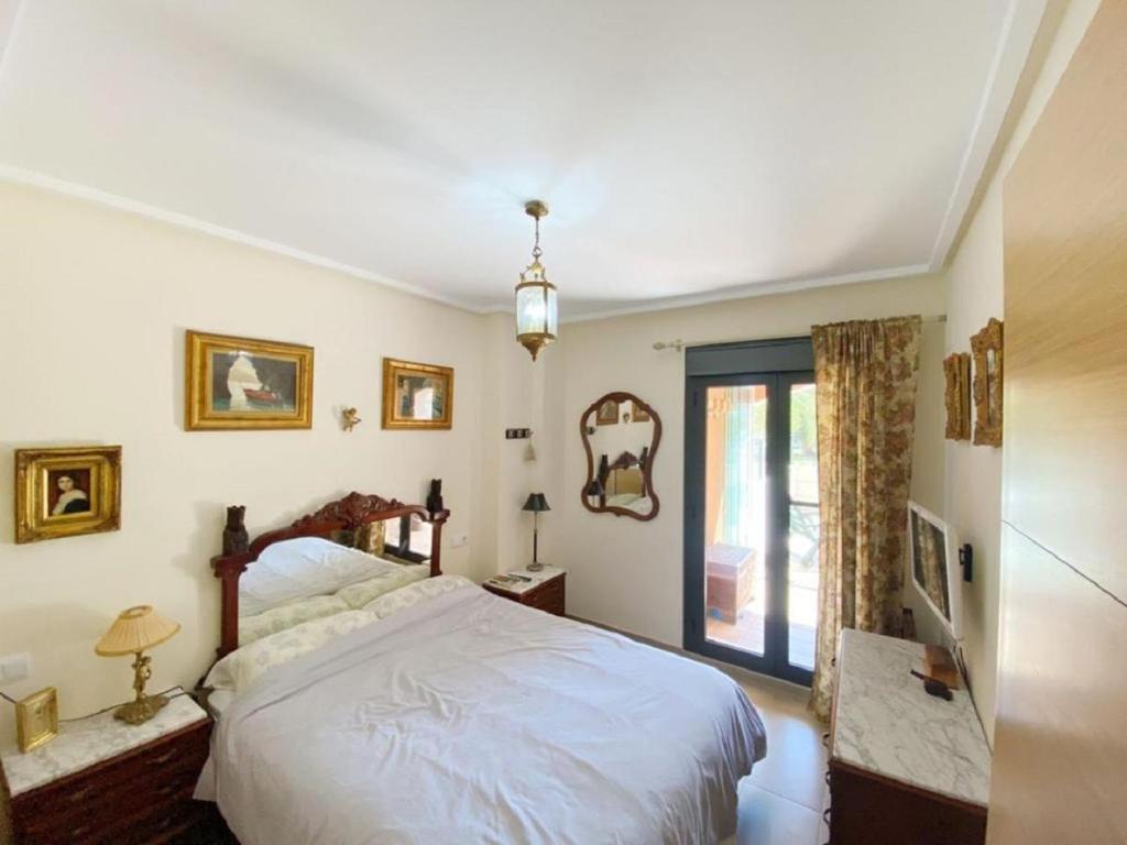 Un dormitorio con una cama grande y una ventana. en Jardines de las Marinas, en Denia