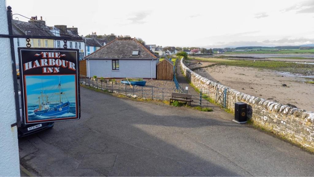 a sign for the harbor inn next to a beach at The Harbour Inn in Garlieston