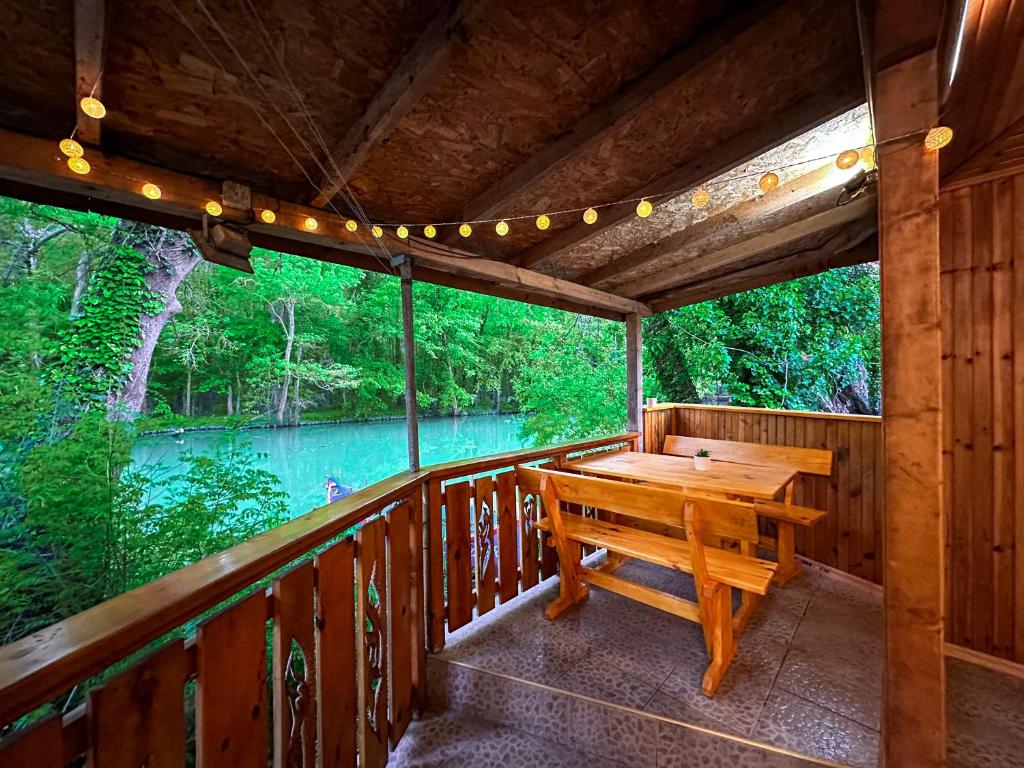 eine Holzterrasse mit einem Holztisch auf einer Terrasse in der Unterkunft “River Romance” Villa in Kamchia