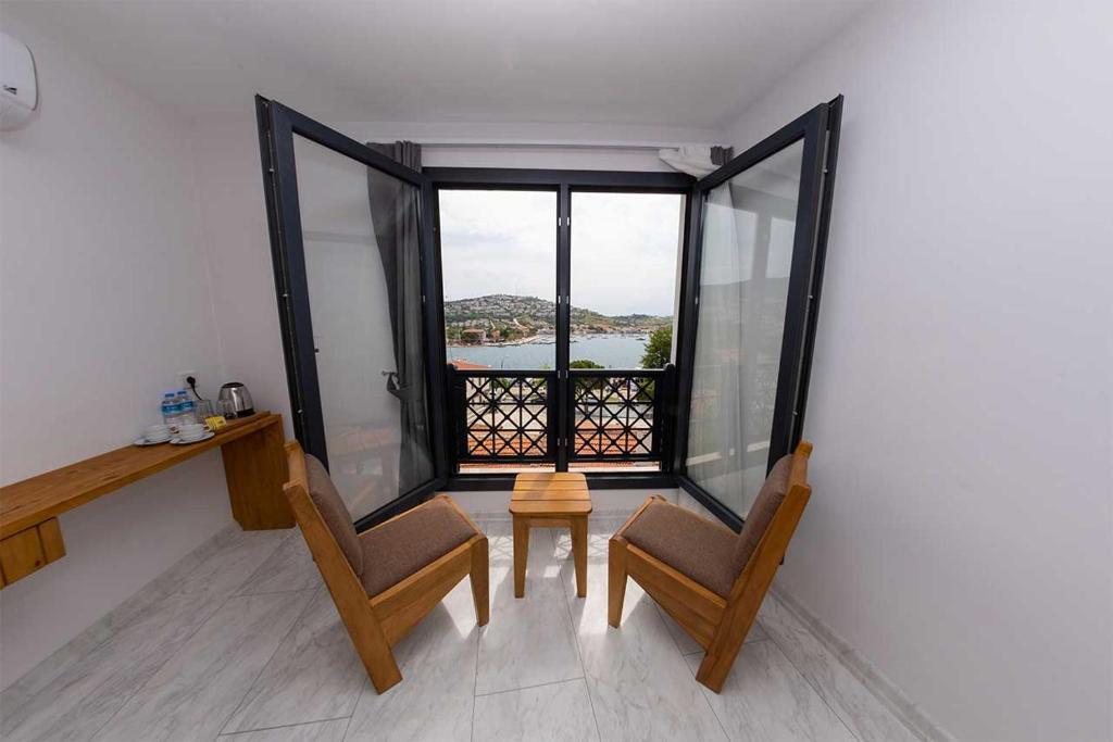 a room with two chairs and a large window at Foça Kybele Hotel in Izmir