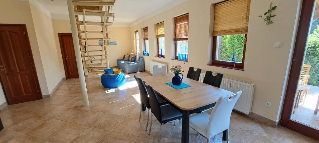 a dining room with a wooden table and chairs at Blue Home in Balatonföldvár