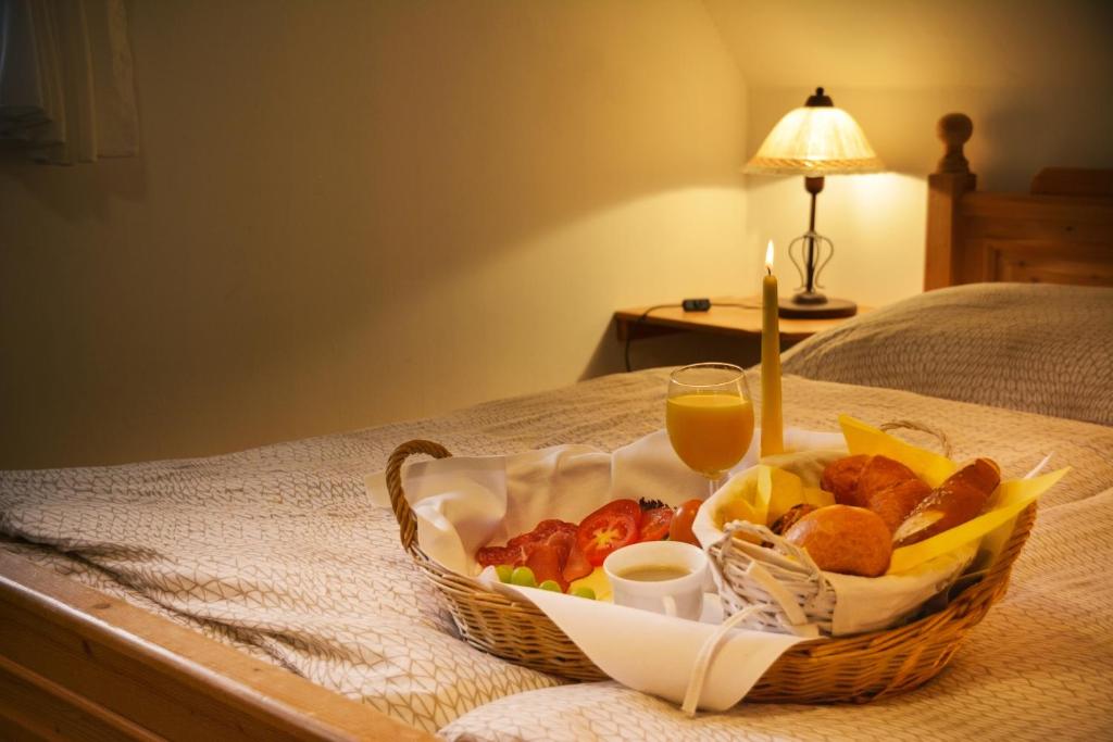 kosz jedzenia na łóżku ze szklanką soku pomarańczowego w obiekcie Gästezimmer Emmis Erbe w mieście Peine