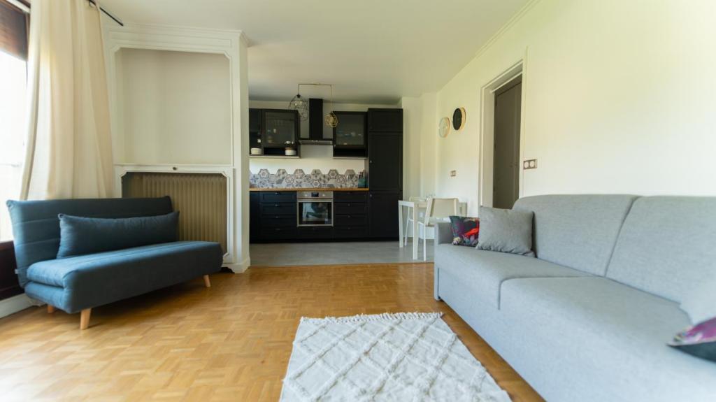a living room with a blue couch and a kitchen at Best place à 15 min de Paris in Saint-Maur-des-Fossés