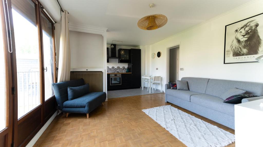 a living room with a blue couch and a chair at Best place à 15 min de Paris in Saint-Maur-des-Fossés