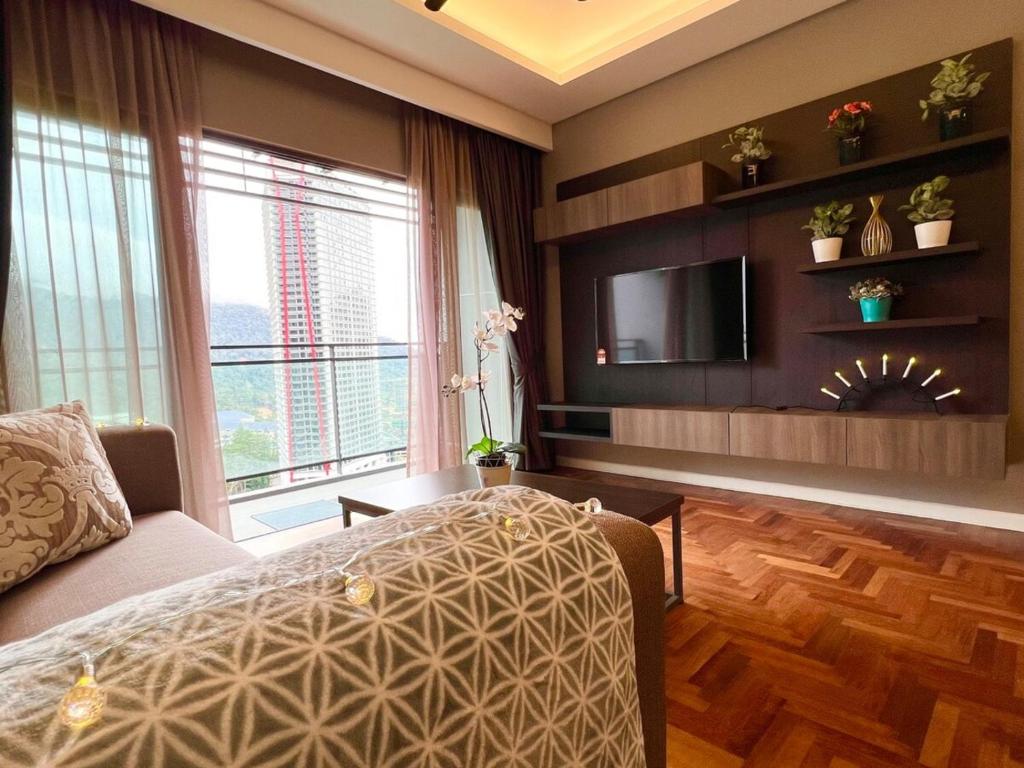 a bedroom with a bed and a flat screen tv at Vista Residence Genting Highland in Genting Highlands