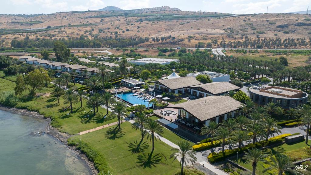uma vista aérea de um resort com uma piscina e palmeiras em The Setai Sea Of Galilee em En Gev