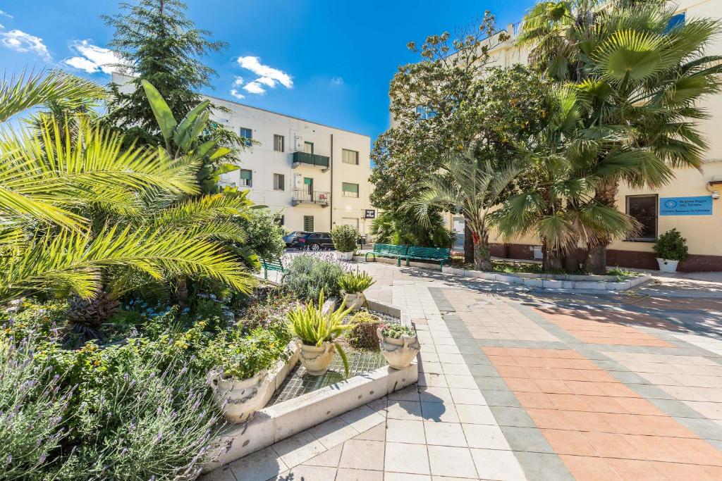 un patio con palmeras y un edificio en Appartamento Vitalba by BarbarHouse en Ginosa Marina