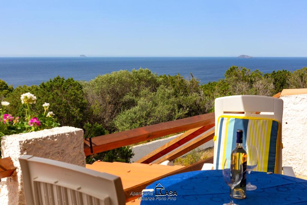- une bouteille de vin assise sur une table avec vue sur l'océan dans l'établissement Apartments Casa Vacanze Porto Pino, à Porto Pino