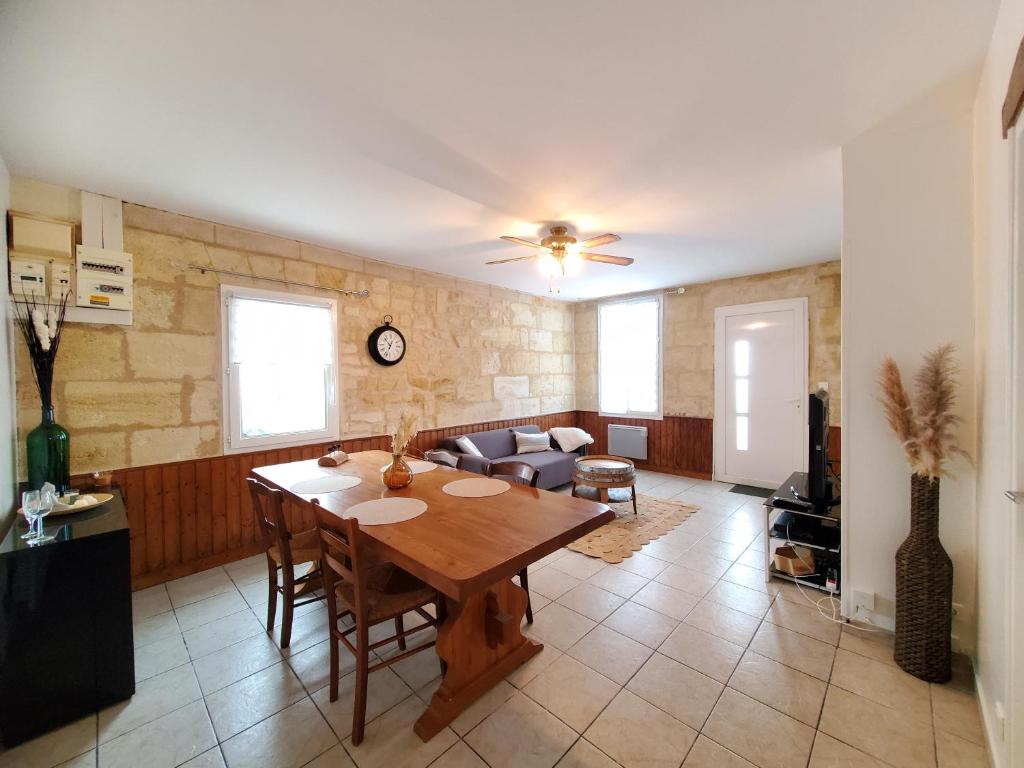 a living room with a table and a couch at Maison de vacances Gite le Margot in Cantenac
